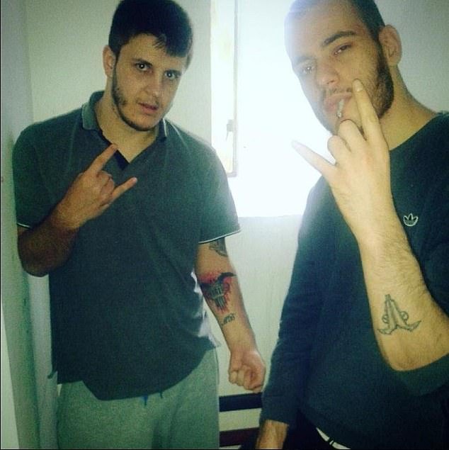 Two Hellbanianz members including 'Gucci' (left) posing in prison. Both have the group's logo tattooed on their arm